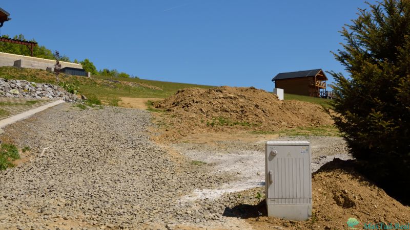 Investičná príležitosť. Pozemok s najkrajším výhľadom na Domaši. - Rekreačné pozemky v Novej Kelči, štrková cesta, drevený dom, svahy a vegetácia.