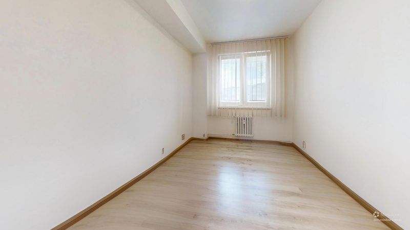 2 izbový prerobený byt v Trenčíne Pred poľom s balkónom - Svetlá miestnosť s oknom a podlahou s dreveným dekorom v 2-izbovom byte.