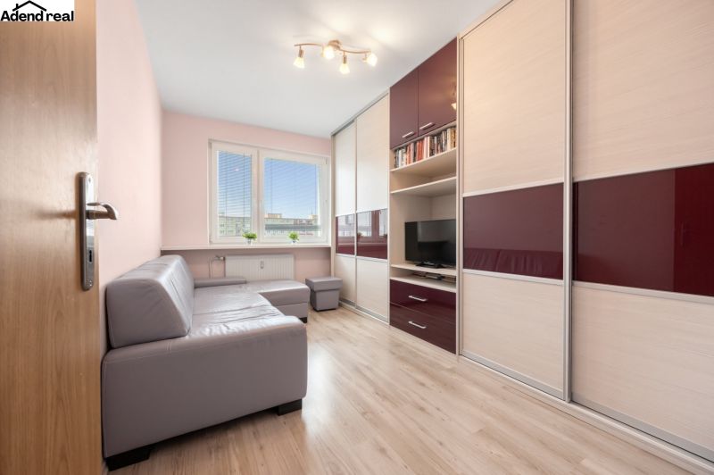 Na prenájom príjemný 3 izbový byt, Vrakuňa, 77 m2. - Obývacia izba v 3-izbovom byte s podlahou s dreveným dekorom a rohovou sedačkou.