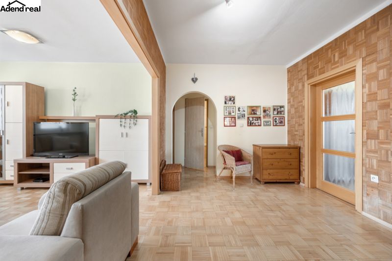 Na prenájom príjemný 3 izbový byt, Vrakuňa, 77 m2. - Obývacia izba v 3-izbovom byte s podlahou s dreveným dekorom a nábytkom.