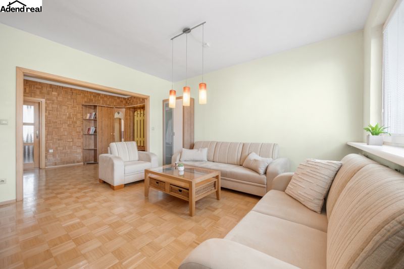 Na prenájom príjemný 3 izbový byt, Vrakuňa, 77 m2. - Obývacia izba v 3-izbovom byte s pohovkami a podlahou s dreveným dekorom.