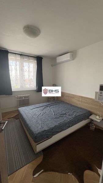 Prenájom 2i-byt s lodžiou s krásnym výhľadom na Račianskej ulici - Spálňa v 2-izbovom byte s kobercami na podlahe s dreveným dekorom.