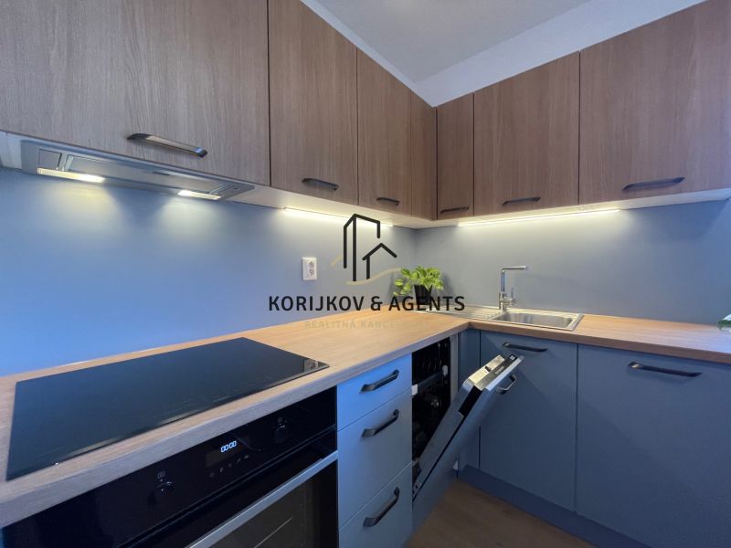 PRENÁJOM, 1,5 izbový byt v novostavbe na Jarkovej, Prešov - Moderná kuchyňa v 2-izbovom byte s podlahou s dreveným dekorom a modrými skrinkami.