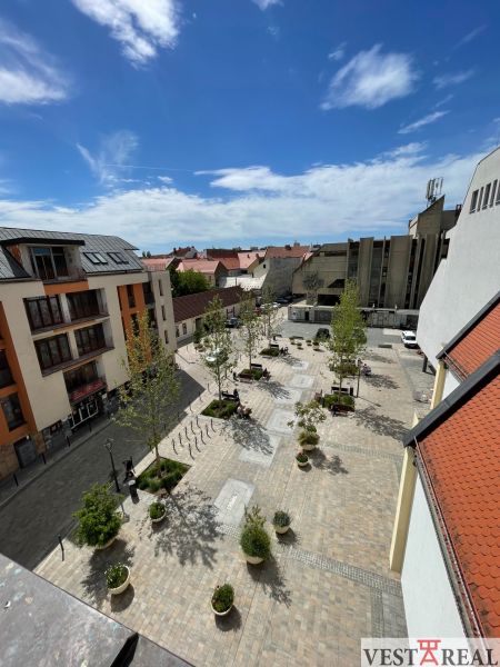 ODSTÚPENIE ZABEHNUTEJ KAVIARNE V CENTRE TRNAVY – TROJIČNÉ NÁMESTIE - Výhľad na Trojičné námestie v Trnave, s gastro priestormi a zeleňou.