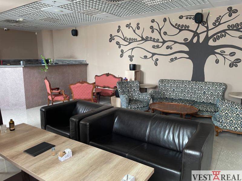 ODSTÚPENIE ZABEHNUTEJ KAVIARNE V CENTRE TRNAVY – TROJIČNÉ NÁMESTIE - Gastro priestory s koženými kreslami, vzorovanými sedačkami a dekoráciami na stene.