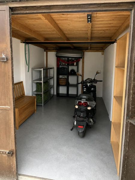 Predám murovanú garáž v Nových Zámkoch - Garáže s motocyklom, dreveným stropom a policami na uskladnenie.