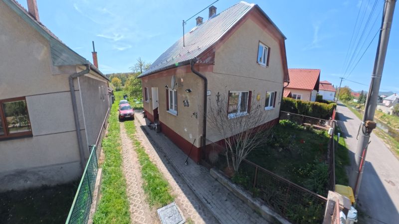 Dobré Reality ponúkajú rodinný dom s veľkou záhradou v obci Svinná  - Rodinný dom v Svinné s automobilom na príjazdovej ceste a udržiavanou záhradou.