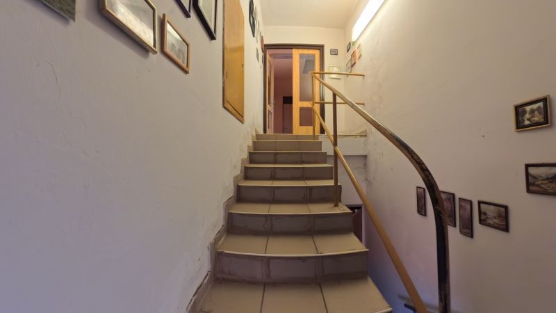 Dobré Reality ponúkajú rodinný dom s veľkou záhradou v obci Svinná  - Schodisko s dreveným zábradlím v rodinnom dome, ozdobené obrázkami.