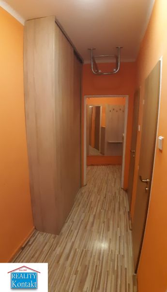Na prenájom 2-izbový byt - Nové Zámky - Chodba s oranžovými stenami a podlahou s dreveným dekorom v 2-izbovom byte.