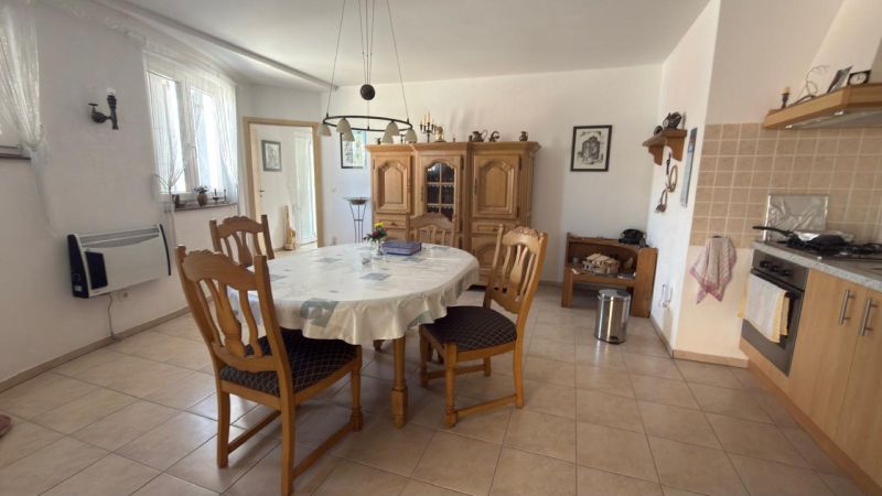 CHORVÁTSKO - Dom s krásnym výhľadom na Velebit a more - VINJERAC - Kuchyňa v rodinnom dome s okrúhlym stolom, drevenými stoličkami a kredencom.