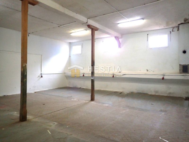 Hala na prenájom 400 m2 - priemyselná zóna - Prázdne výrobné priestory so stĺpmi, bielymi stenami a podlahou vhodné na úpravy.