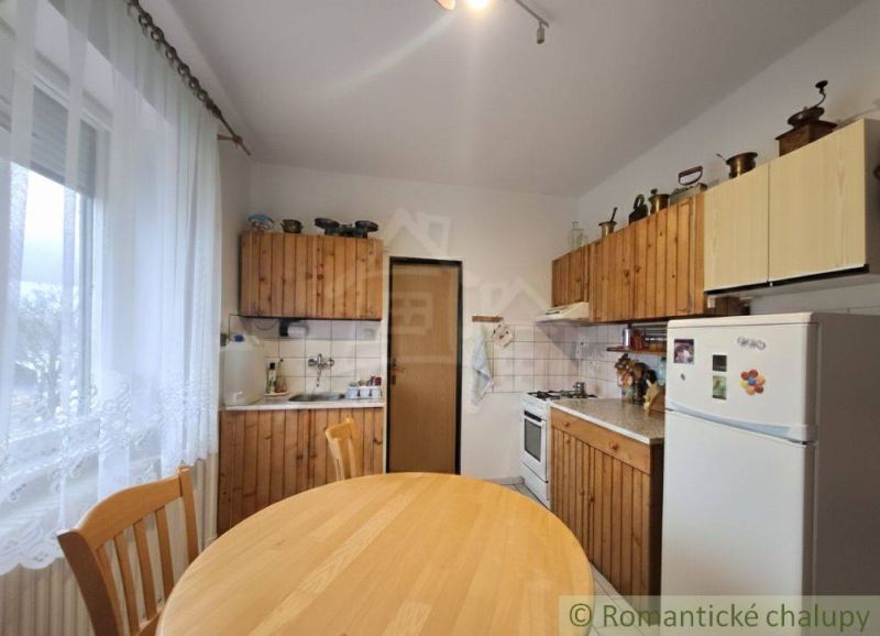 Vymením dom s veľkou záhradou v obci Mýtna za 2 i byt v Lučenci - Kuchyňa v rodinnom dome s drevenými skrinkami, jedálenský stôl, chladnička, stoličky.