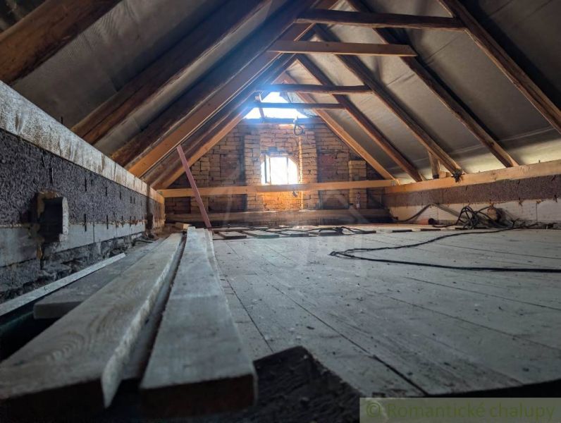 SOBOTIŠTE – VIDIECKY DOM PO ZÁSADNEJ REKONŠTRUKCII ( PRIPRAVENÝ NA DOK - Podkrovie s odhalenými trámami a podlahou s dreveným dekorom v rodinnom dome.