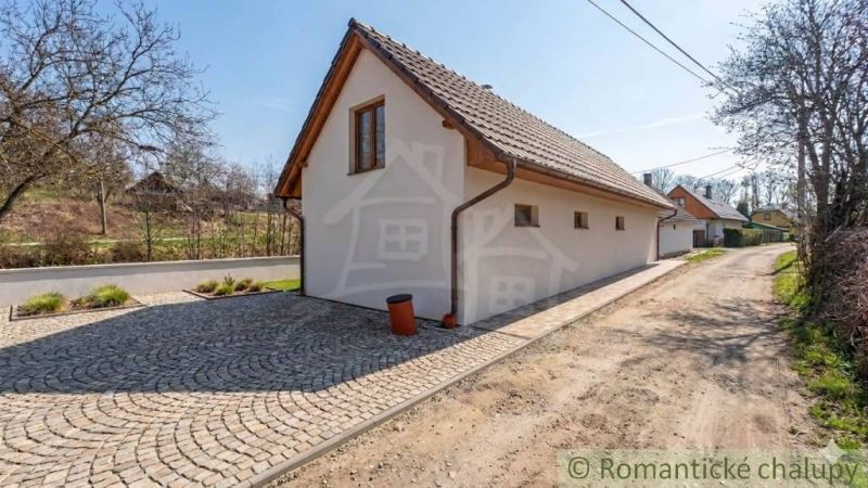 SOBOTIŠTE – VIDIECKY DOM PO ZÁSADNEJ REKONŠTRUKCII ( PRIPRAVENÝ NA DOK - Rodinný dom v Sobotišti s dláždenou príjazdovou cestou, obklopený zeleňou a stromami.