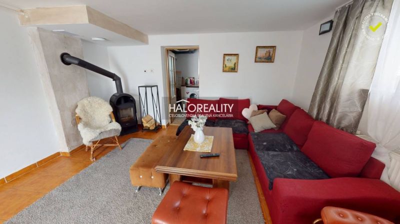 Predaj, rodinný dom Vitanová - EXKLUZÍVNE HALO REALITY - Obývačka v rodinnom dome s krbom, pohodlnou pohovkou a dreveným stolom.