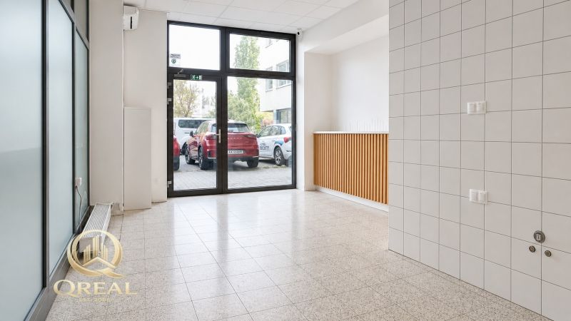 *Prenájom obchodného priestoru s výkladom, 26,3 m² – Račianske mýto* - Svetlá miestnosť s veľkými oknami a dlažbou, ideálna pre obchodné priestory.