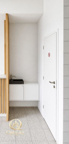 *Prenájom obchodného priestoru s výkladom, 26,3 m² – Račianske mýto* - Biely interiér obchodných priestorov s umývadlom a dverami.
