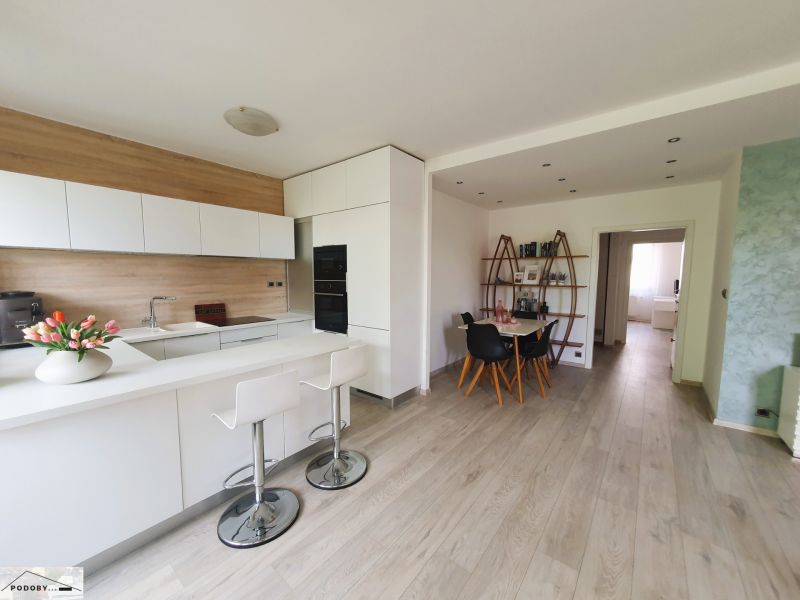 Kováčska ul. - predaj 3 izbového bytu - Kuchyňa s jedálenským kútom, bielymi skrinkami a podlahou s dreveným dekorom v 3-izbovom byte.