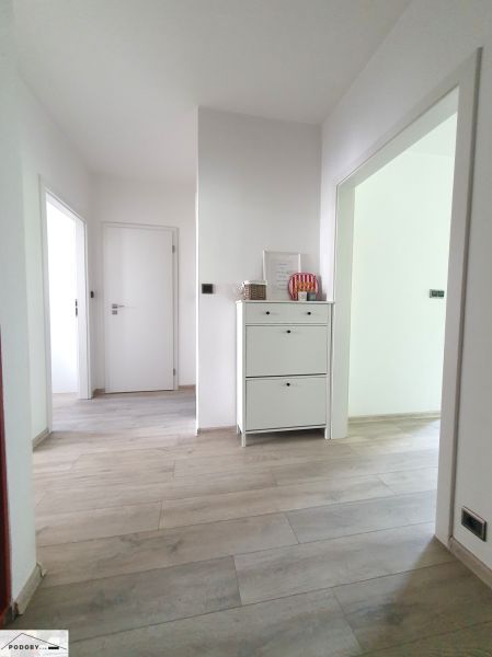 Kováčska ul. - predaj 3 izbového bytu - Chodba s bielym nábytkom a podlahou s dreveným dekorom v 3-izbovom byte.