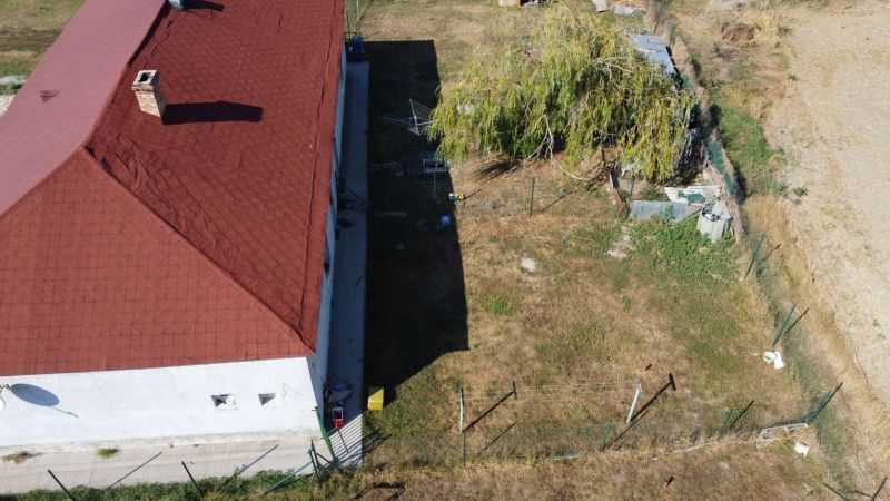 NA PREDAJ 3-IZBOVÝ RD (ČASŤ DVOJDOMU), ZEMIANSKA OLČA - Rodinný dom v Zemianskej Olči s červenou strechou a dvorom s veľkým stromom.