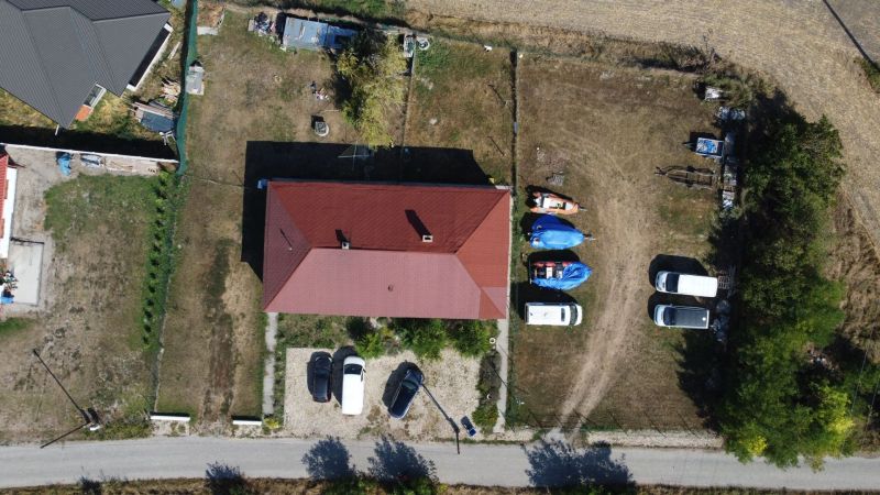 NA PREDAJ 3-IZBOVÝ RD (ČASŤ DVOJDOMU), ZEMIANSKA OLČA - Letecký pohľad na rodinný dom v Zemianskej Olči s priestranným dvorom a zaparkovanými autami.