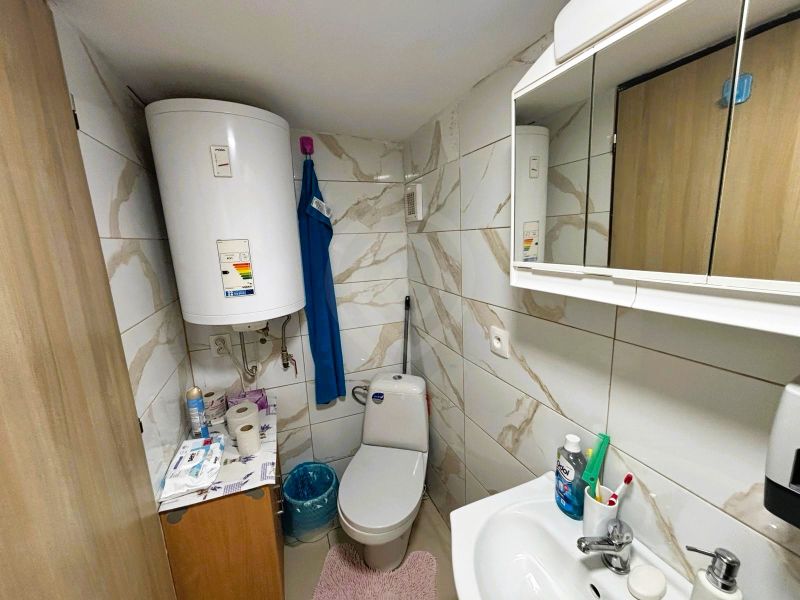 Celoročne obývateľná chata v Gabčíkove na 150 m² pozemku pri Dunaji - Kúpeľňa s obkladmi a bojlerom, ponúka základné hygienické potreby a úložný priestor.