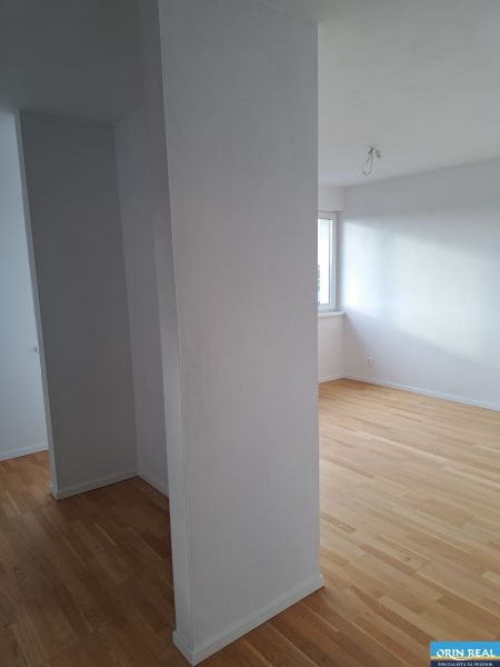 PREDAJ NADŠTANDARDNÉHO 4 IZB.BYTU V NOVOM KOMPLEXE-VINICE-150,18 m2 - Interiér 4-izbového bytu s drevenými podlahami a bielymi stenami na ulici Obchodná.