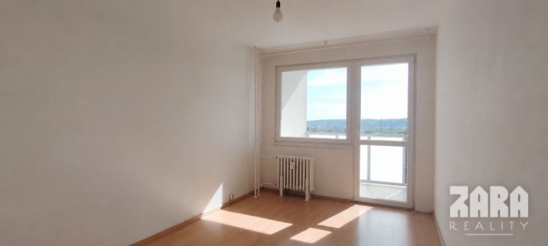 Ťahanovce - 4 izbový byt,  82 m2 + loggia. Krásny výhľad na mesto - Izba s podlahou s dreveným dekorom a veľkým oknom v 4-izbovom byte.