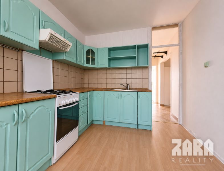 Ťahanovce - 4 izbový byt,  82 m2 + loggia. Krásny výhľad na mesto - Kuchyňa s tyrkysovými skrinkami a podlahou s dreveným dekorom v 4-izbovom byte.