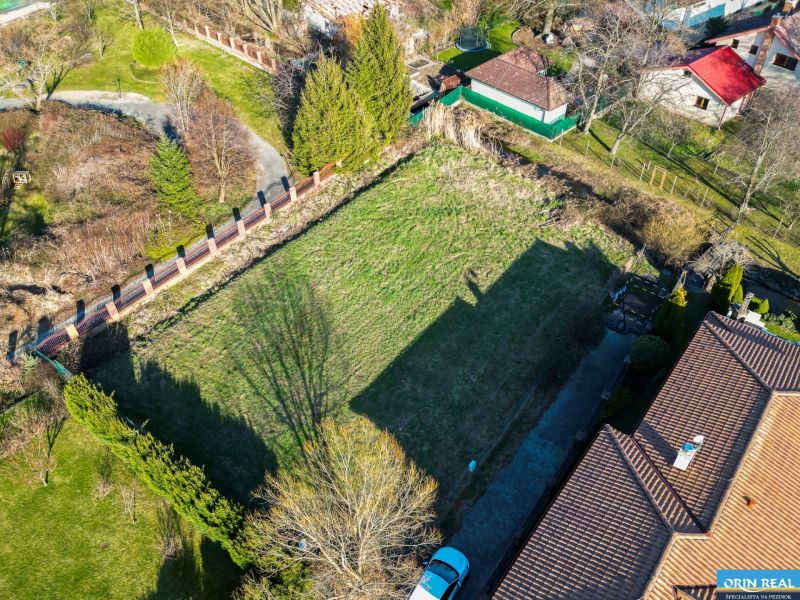  SP V LIMBACHU - 1310 m2 - SO ST.POVOLENÍM A PROJEKTOM V CENE - Záber z výšky ukazuje pozemky na bývanie na ulici Družstevná, ohraničené zeleňou.