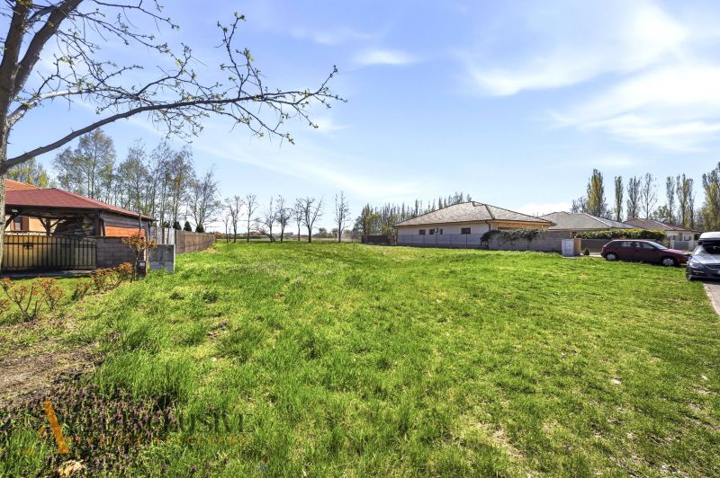 Na predaj 1046 m² stavebný pozemok, Malé Dvorníky - Slnečné pozemky na bývanie v Malých Dvorníkoch, obklopené trávnatými plochami a stavbami.