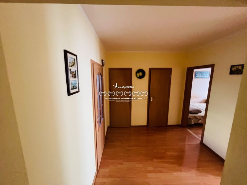 Predaj 3-izbového bytu, Michalská, Michalská, Hlohovec - Chodba s podlahou s dreveným dekorom v 3-izbovom byte, viacero dverí po stranách.