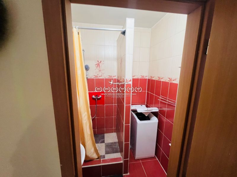 Predaj 3-izbového bytu, Michalská, Michalská, Hlohovec - Kúpeľňa v 3-izbovom byte s práčkou, sprchou a červenými obkladmi.