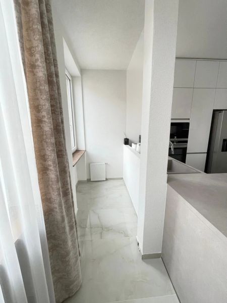 Veľkorysý 3 izbový byt 87m2 po rekonštrukcii, Wiener Neustadt - Kuchyňa v 3-izbovom byte s bielymi skrinkami a mramorovou podlahou.