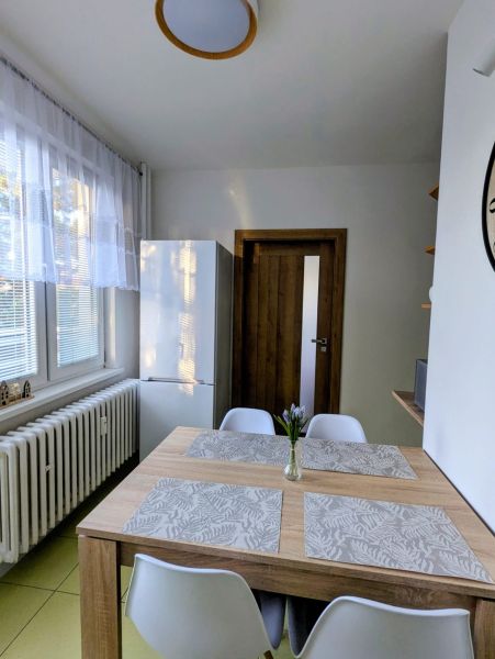 2izbový byt na prenájom v Dubnici nad Váhom  - Jedálenský kút v 2-izbovom byte s dreveným stolom a bielymi stoličkami.