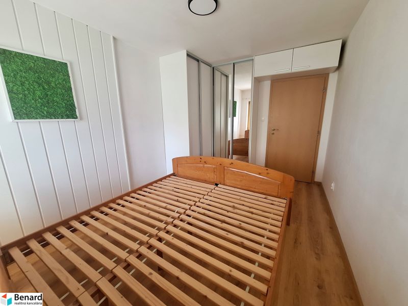 NA PRENÁJOM 2 IZBOVÝ TEHLOVÝ BYT, 55 M2, PREŠOV, ŠIRŠIE CENTRUM - Spálňa v 2-izbovom byte s drevenou posteľou, vstavanou skriňou a dekoráciou na stene.