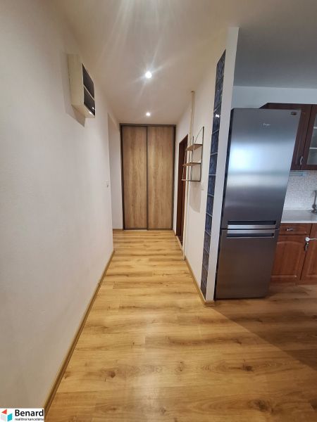 NA PRENÁJOM 2 IZBOVÝ TEHLOVÝ BYT, 55 M2, PREŠOV, ŠIRŠIE CENTRUM - Chodba so vstavanou skriňou a kuchyňou v 2-izbovom byte, drevená podlaha, svetlé steny.