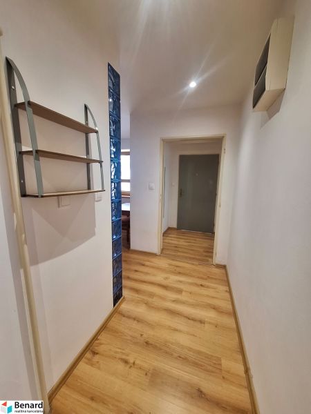 NA PRENÁJOM 2 IZBOVÝ TEHLOVÝ BYT, 55 M2, PREŠOV, ŠIRŠIE CENTRUM - Chodba v 2-izbovom byte s drevenou podlahou a policou na stene.