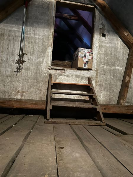 Vidiecky dom na predaj Mikulášov - Podkrovie rodinného domu s drevenými schodmi a balíkom.