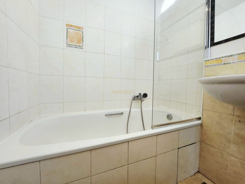 - PRENÁJOM - 2 IZBOVÝ BYT - JAKUBOVO NÁMESTIE - STARÉ MESTO - Kúpeľňa v 2-izbovom byte s vaňou a umývadlom, obložená svetlými dlaždicami.