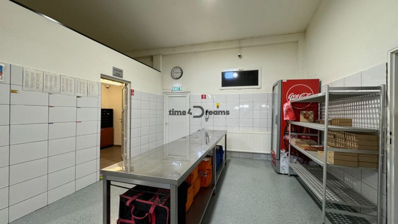 ODSTÚPENIE gastro prevádzky PIZZA Top v Nitre - Gastro priestory so skladom, bielymi obkladmi, chladničkou a kovovými regálmi na uskladnenie.