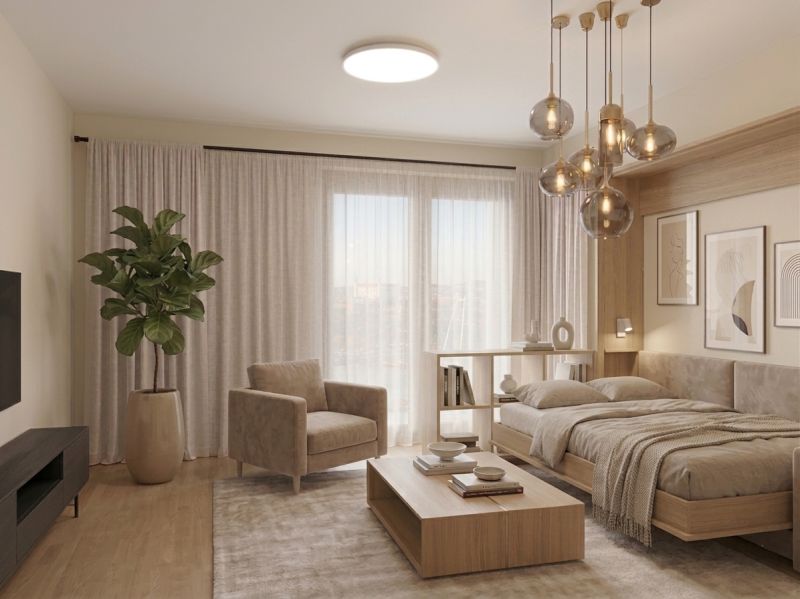 I Predaj Výnimočný  1-izb apartmán v projekte Metropolis - 1-izbový byt s pohovkou, posteľou, podlahou s dreveným dekorom a izbovou rastlinou.