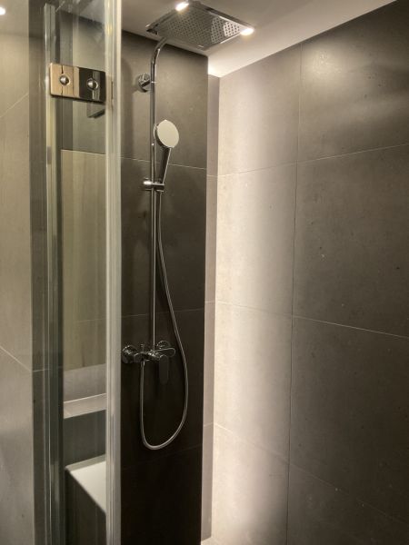 I Predaj Výnimočný  1-izb apartmán v projekte Metropolis - Sprchový kút so sivými obkladmi v 1-izbovom byte.