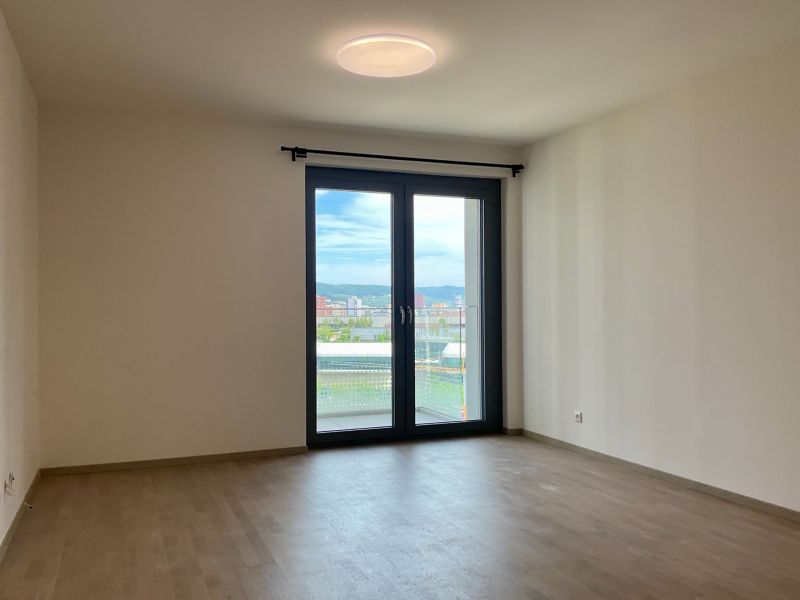 I Predaj Výnimočný  1-izb apartmán v projekte Metropolis - 1-izbový byt s podlahou s dreveným dekorom a balkónovými dverami.