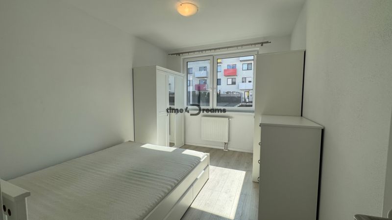 NA PRENÁJOM  2 izbový byt s GARÁŽOU Nitra - Svetlá spálňa v 2-izbovom byte, posteľ, skriňa, okno, podlaha s dreveným dekorom.