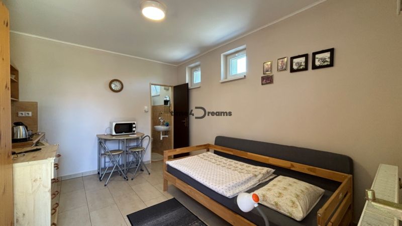 NA PREDAJ Ubytovňa v obci Bílkové Humence - Izba s pohovkou, kuchynkou s mikrovlnkou, dekoráciami na stene, je vhodná pre hotely a penzióny.