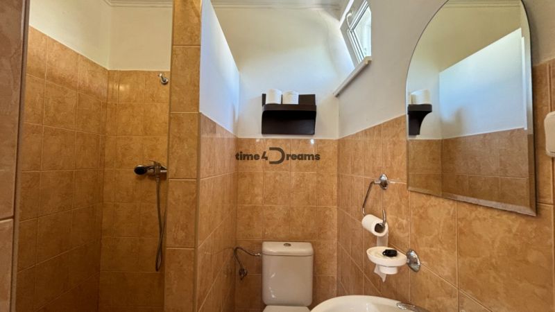 NA PREDAJ Ubytovňa v obci Bílkové Humence - Kúpeľňa s hnedými obkladačkami, sprchovým kútom, zrkadlom a WC, vhodná pre hotely a penzióny.