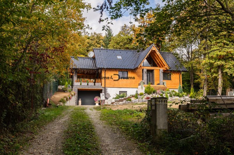 NA PREDAJ čarovná CHATA v srdci Duchonky - Topoľčany  - Chata v Prašiciach obklopená lesom, s dreveným obložením a čiernou strechou.