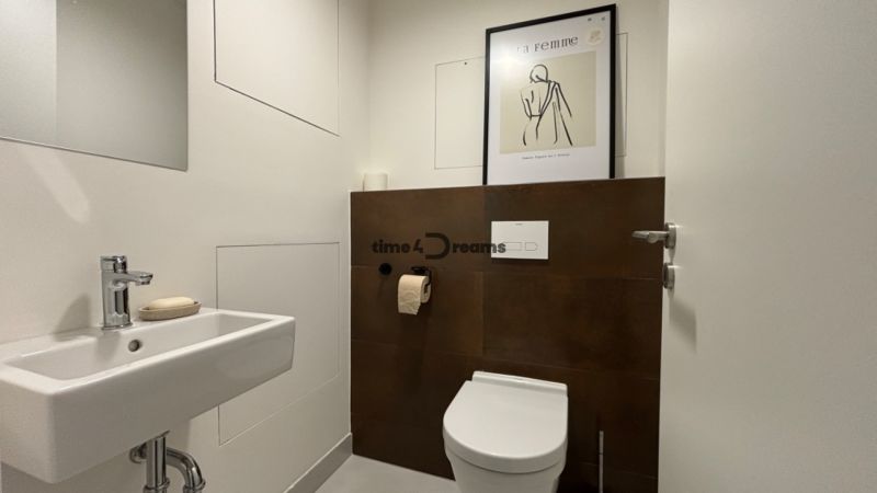 NA PRENÁJOM 2 izbový byt priamo v centre Nitry  - Kúpeľňa v 2-izbovom byte s umývadlom, toaletou a obrazom na stene.