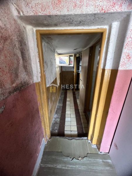 NOVINKA NA TRHU | Rodinný dom v obci Cerová – ideálne miesto pre pokoj - Úzky chodba s poškodenými stenami a dláždenou podlahou v rodinnom dome.